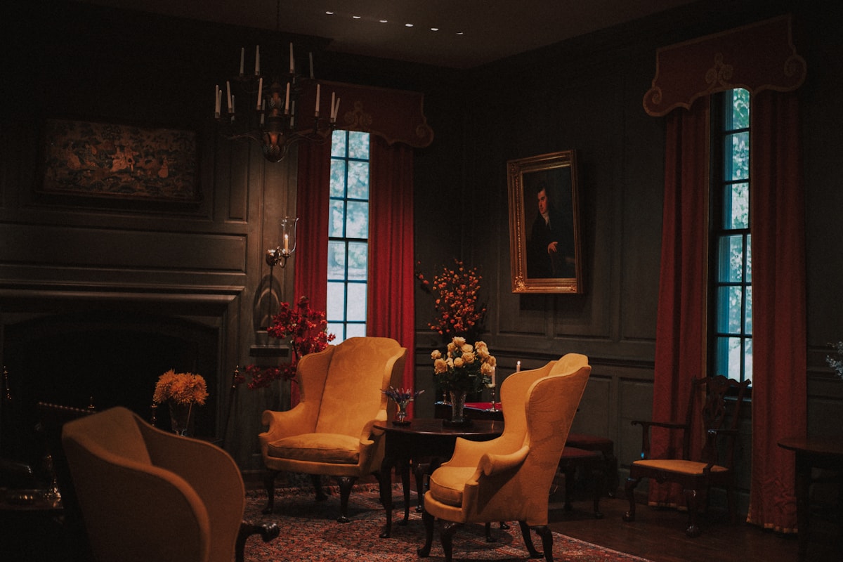 candlelit parlor with a worn velvet sofa and old pastoral prints